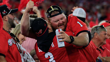 Georgia Bulldogs fans hug it out on a critical fourth down during the fourth quarter of an NCAA football game, Saturday, Nov. 1, 2025, at EverBank Stadium in Jacksonville, Fla. Georgia held off Florida 24-20. [Corey Perrine/Florida Times-Union]