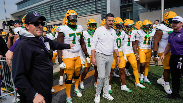 Sep 13, 2025; Evanston, Illinois, USA; Oregon Ducks head coach Dan Lanning leads his team on the field against the Northwestern Wildcats at Northwestern Medicine Field at Martin Stadium. Mandatory Credit: David Banks-Imagn Images