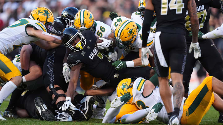 Colorado running back Dallan Hayden is stopped on fourth down by North Dakota State defensive end Loshiaka Roques and linebacker Logan Kopp in the second quarter at Folsom Field