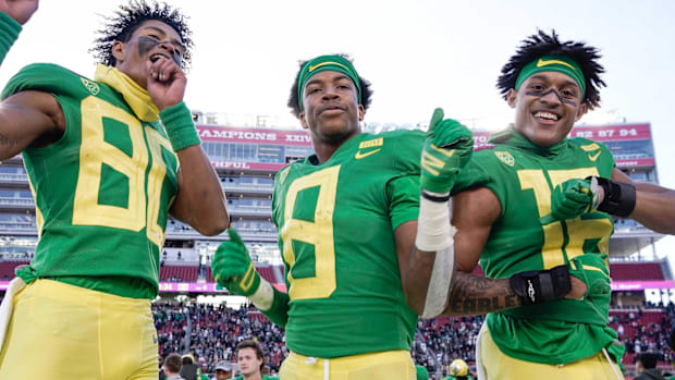Oregon Ducks wide receiver Bryan Addison (80) and safety Jevon Holland (8) and safety Nick Pickett (16) celebrate on the side