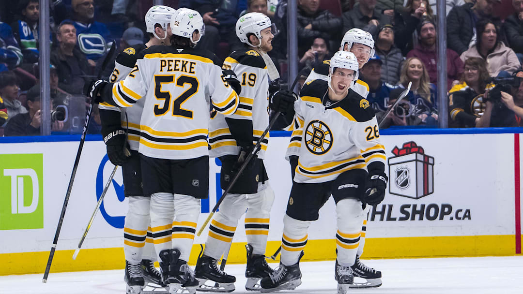 Dec 14, 2024; Vancouver, British Columbia, CAN; Boston Bruins defenseman Andrew Peeke (52) and forward John Beecher (19) and forward Marc McLaughlin (26) and forward Cole Koepke (45) celebrate McLaughlin’s goal against the Vancouver Canucks during the second period at Rogers Arena. Mandatory Credit: Bob Frid-Imagn Images