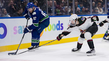 Jan 18, 2024; Vancouver, British Columbia, CAN; Arizona Coyotes forward Matias Maccelli (63) stick checks Vancouver Canucks defenseman Ian Cole (82) in the second period at Rogers Arena. Mandatory Credit: Bob Frid-Imagn Images