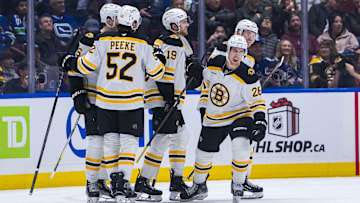 Dec 14, 2024; Vancouver, British Columbia, CAN; Boston Bruins defenseman Andrew Peeke (52) and forward John Beecher (19) and forward Marc McLaughlin (26) and forward Cole Koepke (45) celebrate McLaughlin’s goal against the Vancouver Canucks during the second period at Rogers Arena. Mandatory Credit: Bob Frid-Imagn Images