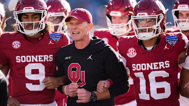 Oklahoma coach Brent Venables locks arms with players before the Armed Forces Bowl football game between the University of Ok