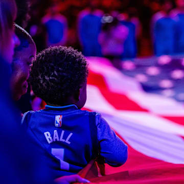 Apr 7, 2024; Charlotte, North Carolina, USA; Young fan holds American flag before the game between the Charlotte Hornets and the Oklahoma City Thunder at Spectrum Center. Mandatory Credit: Scott Kinser-Imagn Images