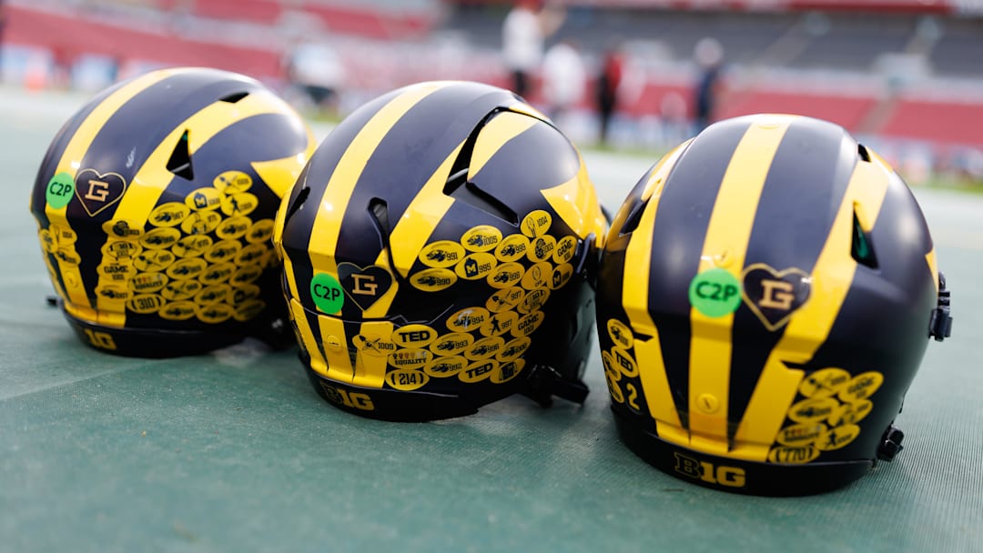 Dec 31, 2024; Tampa, FL, USA; Michigan Wolverines quarterback helmets sit on the field before a game against the Alabama Crimson Tide at Raymond James Stadium.