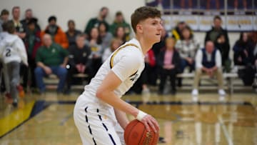 Whitnall senior Austin Herro spots up for a three-pointer during Whitnall's 61-47 loss to Greenfield on Friday. Austin's brother Tyler had his number 14 jersey retired at halftime.