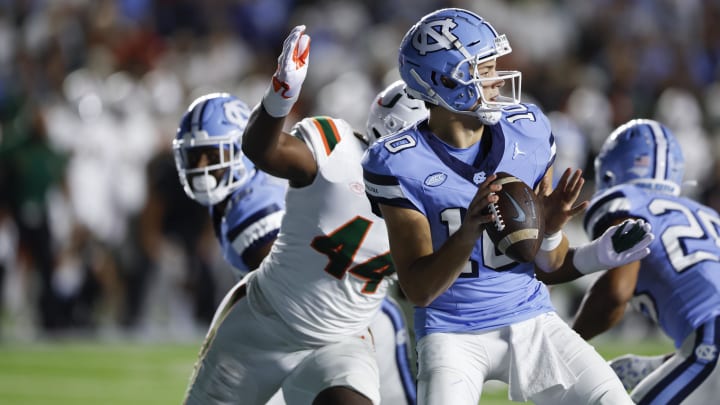 Oct 14, 2023; Chapel Hill, North Carolina, USA; North Carolina Tar Heels quarterback Drake Maye (10) looks to pass as he is chased by Miami Hurricanes defensive lineman Rueben Bain Jr. (44) in the first half at Kenan Memorial Stadium. Mandatory Credit: Nell Redmond-USA TODAY Sports