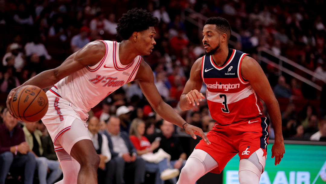 Nov 12, 2025; Houston, Texas, USA; Houston Rockets guard Amen Thompson (1) handles the ball against Washington Wizards guard CJ McCollum (3) during the third quarter at Toyota Center. Mandatory Credit: Erik Williams-Imagn Images