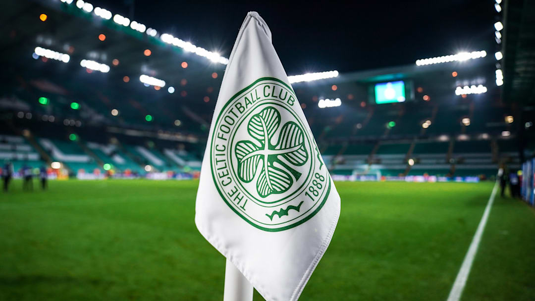 Detailed shot of a corner flag with the Celtic Glasgow coat of arms, illuminated stadium in the background. Detailed shot of a corner flag with the Celtic Glasgow coat of arms, illuminated stadium in the background.