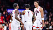 Arizona Wildcats guard Caleb Love (1) celebrates a three-point basket with his teammates Jaden Bradley (0) and Carter Bryant (3).