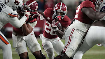 Nov 30, 2024; Tuscaloosa, Alabama, USA;  Alabama Crimson Tide running back Justice Haynes (22) runs behind offensive lineman Parker Brailsford (72) and offensive lineman Tyler Booker (52) against the Auburn Tigers during the second half at Bryant-Denny Stadium. Alabama won 28-14. Mandatory Credit: Gary Cosby Jr.-Imagn Images