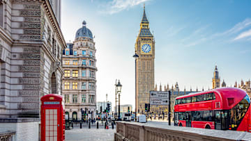 Red telephone box and double-decker bus on Parliament square and Big Ben tower, London, UK