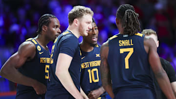 Nov 28, 2024; Paradise Island, Bahamas, BHS;  West Virginia Mountaineers guard Toby Okani (5) and West Virginia Mountaineers guard Sencire Harris (10) and West Virginia Mountaineers guard Tucker DeVries (12) and West Virginia Mountaineers guard Javon Small (7) huddle before the game against the Louisville Cardinals at Imperial Arena at the Atlantis resort.  Mandatory Credit: Kevin Jairaj-Imagn Images