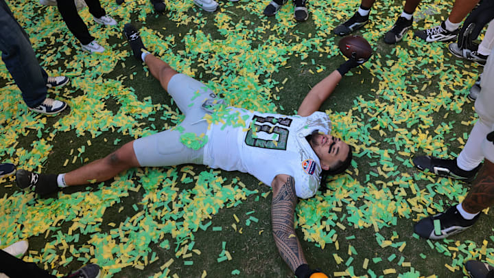 Jan 1, 2026; Miami Gardens, FL, USA; Oregon Ducks linebacker Matayo Uiagalelei (10) makes a confetti angel following the 2025 Orange Bowl and quarterfinal game of the College Football Playoff against the Texas Tech Red Raiders at Hard Rock Stadium. Mandatory Credit: Sam Navarro-Imagn Images