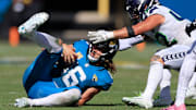 Jacksonville Jaguars quarterback Trevor Lawrence (16) slides for a first down pickup against Seattle Seahawks linebacker Drake Thomas (42) during the fourth quarter of an NFL football matchup, Sunday, Oct. 12, 2025, at EverBank Stadium in Jacksonville, Fla. The Seahawks defeated the Jaguars 20-12.