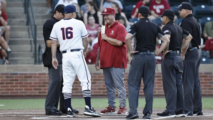 Jun 1, 2024; Norman, OK, USA; UConn Huskies head coach Jim Penders, left, and Oklahoma Sooners head coach Skip Johnson, right, meet before the start of an NCAA Division I Baseball Championship game between the UConn Huskies and the Oklahoma Sooners at L. Dale Mitchell Park. Credit: Alonzo Adams-USA TODAY Sports