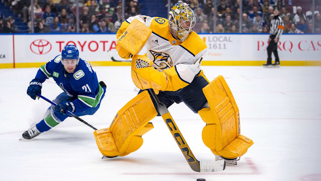 Jan 3, 2025; Vancouver, British Columbia, CAN; Vancouver Canucks forward Nils Hoglander (21) watches Nashville Predators goalie Juuse Saros (74) handle the puck in the second period at Rogers Arena. Mandatory Credit: Bob Frid-Imagn Images