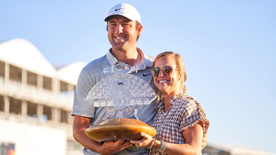 Scottie Scheffler and Meredith Scudder hold the 2022 WM Phoenix Open trophy. 