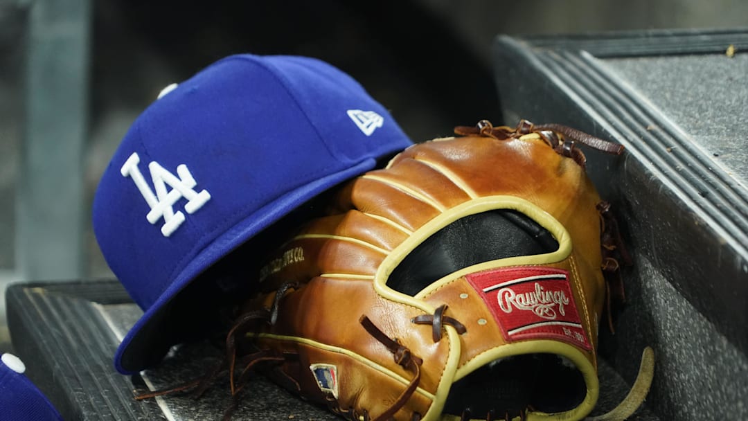 Apr 28, 2024; Toronto, Ontario, CAN; A hat and glove of an Los Angeles Dodgers player durng a game against the Toronto Blue Jays at Rogers Centre. Mandatory Credit: John E. Sokolowski-Imagn Images