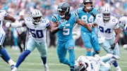 Oct 12, 2025; Charlotte, North Carolina, USA; Carolina Panthers running back Rico Dowdle (5) runs with the ball while getting pressured by Dallas Cowboys linebacker Shemar James (50) during the second half at Bank of America Stadium. Mandatory Credit: Scott Kinser-Imagn Images