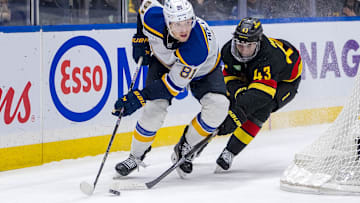 Dec 10, 2024; Vancouver, British Columbia, CAN; Vancouver Canucks defenseman Quinn Hughes (43) stick checks St. Louis Blues forward Dylan Holloway (81) during the third period at Rogers Arena. Mandatory Credit: Bob Frid-Imagn Images