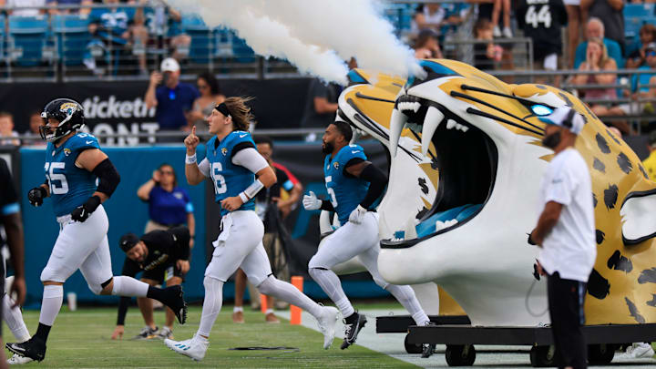 Jacksonville Jaguars quarterback Trevor Lawrence (16), center, runs onto the field with center Mitch Morse (65), left, and safety Andre Cisco (5) before a preseason NFL football game Saturday, Aug. 10, 2024 at EverBank Stadium in Jacksonville, Fla. The Jacksonville Jaguars defeated the Kansas City Chiefs 26-13. 