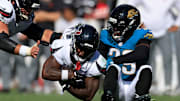 Houston Texans running back Woody Marks (27) leaps for yards against Jacksonville Jaguars safety Eric Murray (29) during the fourth quarter of an NFL football matchup at EverBank Stadium, Sunday, Sept. 21, 2025, in Jacksonville, Fla. The Jaguars defeated the Texans 17-10.