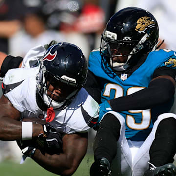 Houston Texans running back Woody Marks (27) leaps for yards against Jacksonville Jaguars safety Eric Murray (29) during the fourth quarter of an NFL football matchup at EverBank Stadium, Sunday, Sept. 21, 2025, in Jacksonville, Fla. The Jaguars defeated the Texans 17-10.