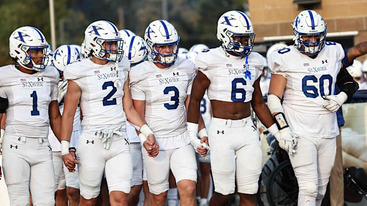 St. Xavier players Kobe Clapper (1), Brayden Reilly (2), Daniel Vollmer (3), Aden Reeder (6) and Grant Hester (60) walk on the field before their football game against Moeller Friday, Sept. 19, 2025. St. Xavier players Kobe Clapper (1), Brayden Reilly (2), Daniel Vollmer (3), Aden Reeder (6) and Grant Hester (60) walk on the field before their football game against Moeller Friday, Sept. 19, 2025.
