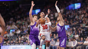 Mar 17, 2025; Salt Lake City, Utah, USA;  Chicago Bulls guard Tre Jones (30) goes between Utah Jazz center Walker Kessler (24) and guard Johnny Juzang (33) and to the basket during the second half at Delta Center. Mandatory Credit: Chris Nicoll-Imagn Images