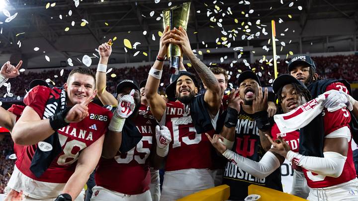 Jan 19, 2026; Miami Gardens, FL, USA; Indiana Hoosiers wide receiver Elijah Sarratt (13) holds the trophy as he celebrates with offensive lineman Pat Coogan (78), defensive lineman Mikail Kamara and defensive back D'Angelo Ponds (5) after defeating the Miami Hurricanes in the College Football Playoff National Championship game at Hard Rock Stadium. Mandatory Credit: Mark J. Rebilas-Imagn Images