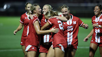 Players celebrate around Reagan Raabe after her goal pushed Nebraska past Purdue.