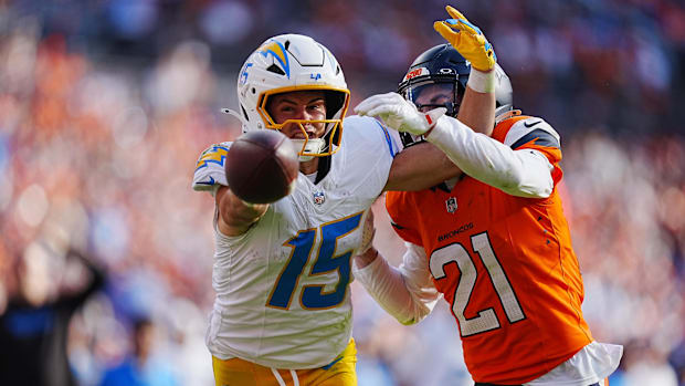 Denver Broncos cornerback Riley Moss (21) breaks up a pass to Los Angeles Chargers wide receiver Ladd McConkey (15).