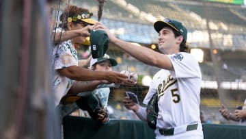 Jul 19, 2024; Oakland, California, USA; Oakland Athletics shortstop Jacob Wilson (5) signs autographs before the start of the game against the Los Angeles Angels at Oakland-Alameda County Coliseum. Mandatory Credit: Cary Edmondson-USA TODAY Sports