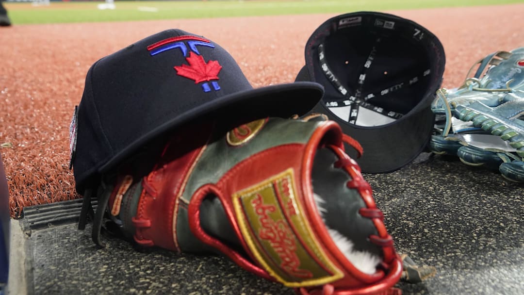 Jul 19, 2024; Toronto, Ontario, CAN; A Toronto Blue Jays hat and glove near the dugout during a game against the Detroit Tigers at Rogers Centre. Mandatory Credit: John E. Sokolowski-Imagn Images