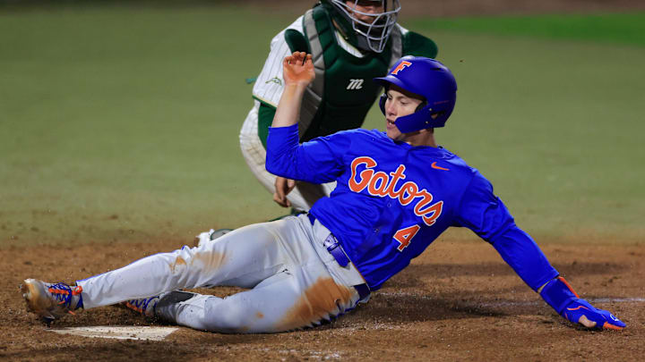 Florida infielder Cade Kurland (4) scores against Jacksonville catcher Nick DeLisi (38) during the eighth inning of an NCAA baseball matchup Monday, Feb. 17, 2025 at Jacksonville University in Jacksonville, Fla. Florida defeated Jacksonville 10-4. [Corey Perrine/Florida Times-Union]