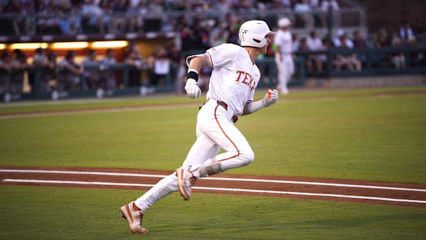 Texas Longhorns infielder Jared Thomas runs around the bases, wearing a white jersey and a matching batting helmet.
