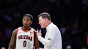 Arizona Wildcats head coach Tommy Lloyd talks with guard Jaden Bradley (0).