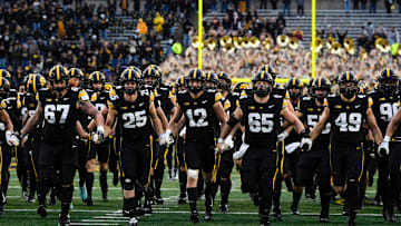 The Iowa Hawkeyes swarm to the Floyd of Rosedale Trophy after defeating the Minnesota Golden Gophers Oct. 25, 2025 at Kinnick Stadium in Iowa City, Iowa.