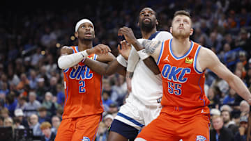 Nov 26, 2025; Oklahoma City, Oklahoma, USA; Oklahoma City Thunder guard Shai Gilgeous-Alexander (2), center Isaiah Hartenstein (55) and Minnesota Timberwolves center Naz Reid (11) react as a rebound comes down during the second half at Paycom Center. Mandatory Credit: Alonzo Adams-Imagn Images