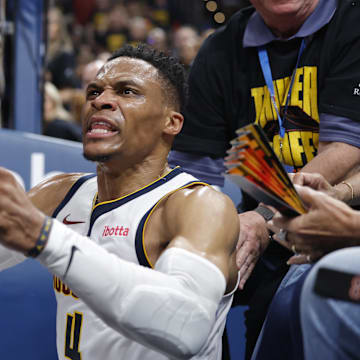 Denver Nuggets guard Russell Westbrook reacts after a play and falling into fans. Mandatory Credit: Alonzo Adams-Imagn Images