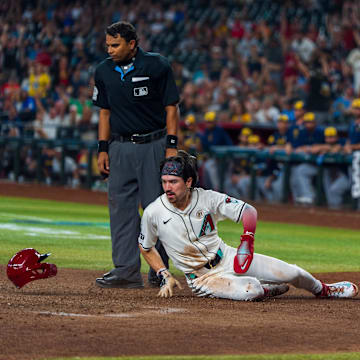 Sep 15, 2024; Phoenix, Arizona, USA; Arizona Diamondbacks outfielder Corbin Carroll (7) loses his helmet as he slides in to score in the eighth inning during a game against the Milwaukee Brewers at Chase Field. Mandatory Credit: Allan Henry-Imagn Images