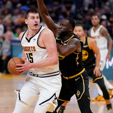 Denver Nuggets center Nikola Jokic (15) controls the ball against Golden State Warriors forward Draymond Green (23) in the second quarter during game one of the first round for the 2022 NBA playoffs at the Chase Center. Mandatory Credit: Cary Edmondson-Imagn Images