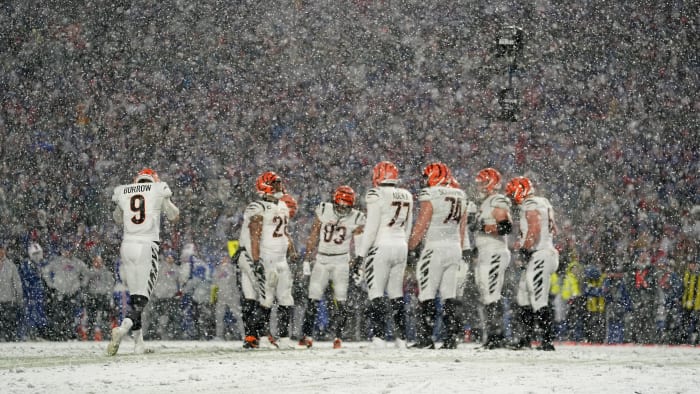 Cincinnati Bengals quarterback Joe Burrow (9) listens to a play call as he joins the huddle before a