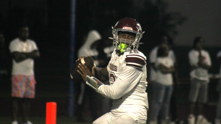 Raines quarterback T.J. Cole (12) prepares to throw a pass against Bolles during a high school football game on August 23, 2024. [Clayton Freeman/Florida Times-Union]