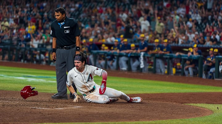 Sep 15, 2024; Phoenix, Arizona, USA; Arizona Diamondbacks outfielder Corbin Carroll (7) loses his helmet as he slides in to score in the eighth inning during a game against the Milwaukee Brewers at Chase Field. Mandatory Credit: Allan Henry-Imagn Images