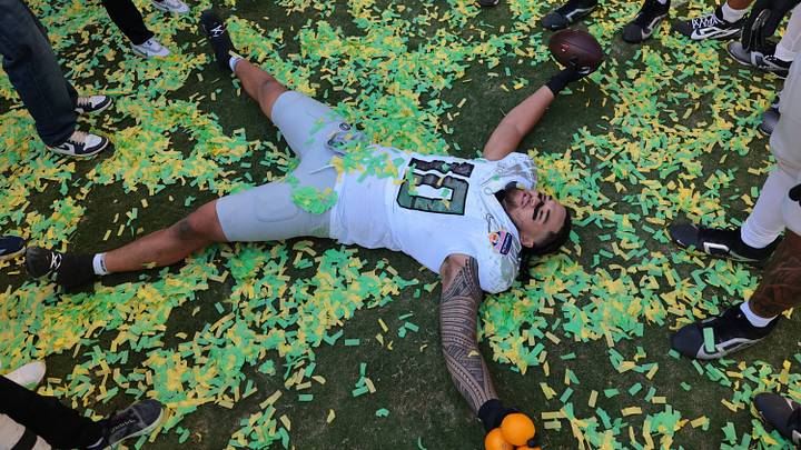 Jan 1, 2026; Miami Gardens, FL, USA; Oregon Ducks linebacker Matayo Uiagalelei (10) makes a confetti angel following the 2025 Orange Bowl and quarterfinal game of the College Football Playoff against the Texas Tech Red Raiders at Hard Rock Stadium. Mandatory Credit: Sam Navarro-Imagn Images