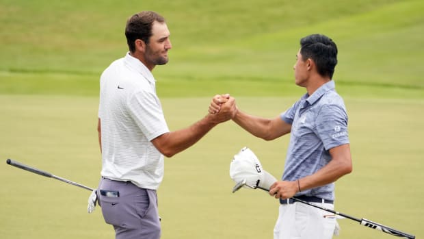 Scottie Scheffler shakes hands with Collin Morikawa on the 18th green.