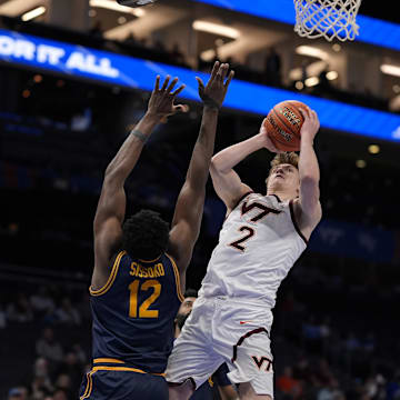 Mar 11, 2025; Charlotte, NC, USA; Virginia Tech guard Jaden Schutt (2) goes to the basket defended by California center Mady Sissoko (12).